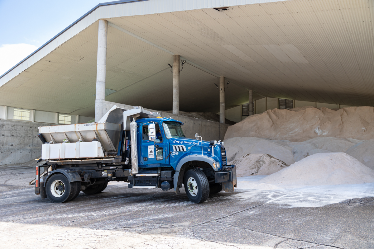Slider hooklift with spreader body