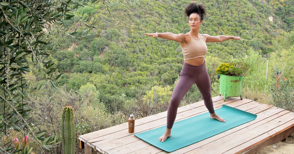 woman doing yoga at her backyard deck