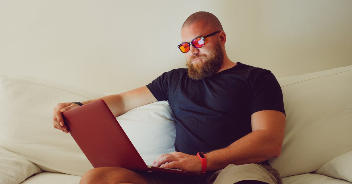 man with blue light blocking glasses looking at his computer screen