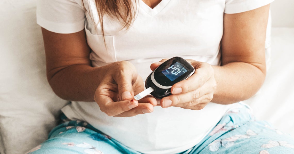 woman measuring her blood glucose level