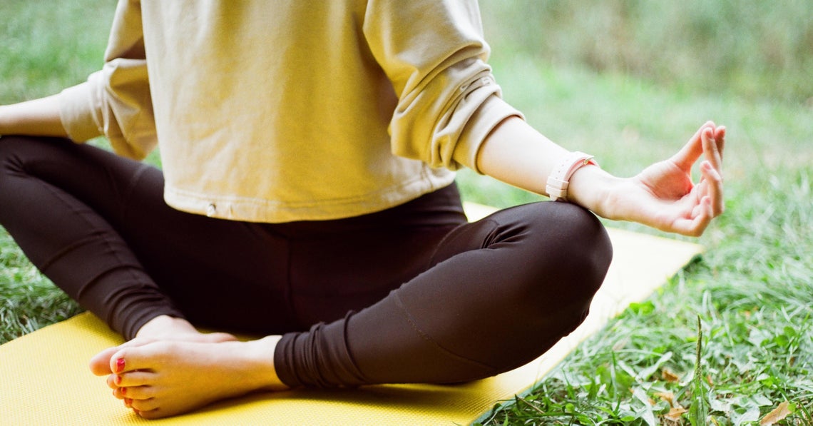 woman doing morning meditation in her back yard