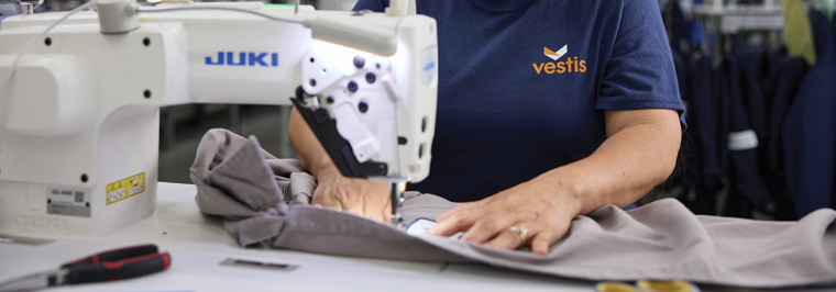 Vestis teammate working with uniform fabrics and sewing