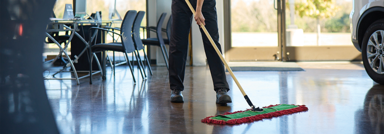 Employee mopping floor with a dust industrial floor mop