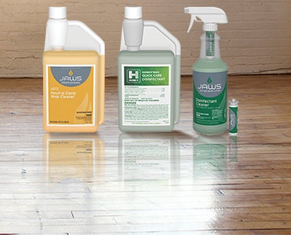 Floor cleaner and surface disinfectant bottles on clean wooden floor