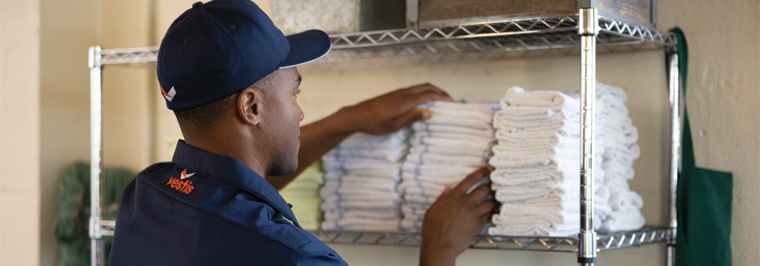 Vestis service representative stocking fresh linens as linen services for restaurants