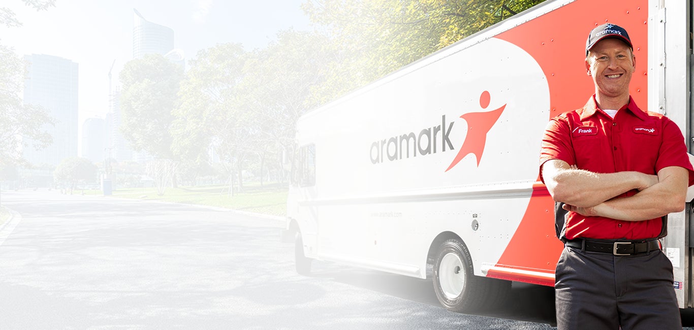 Aramark service representative standing in front of an Aramark delivery truck