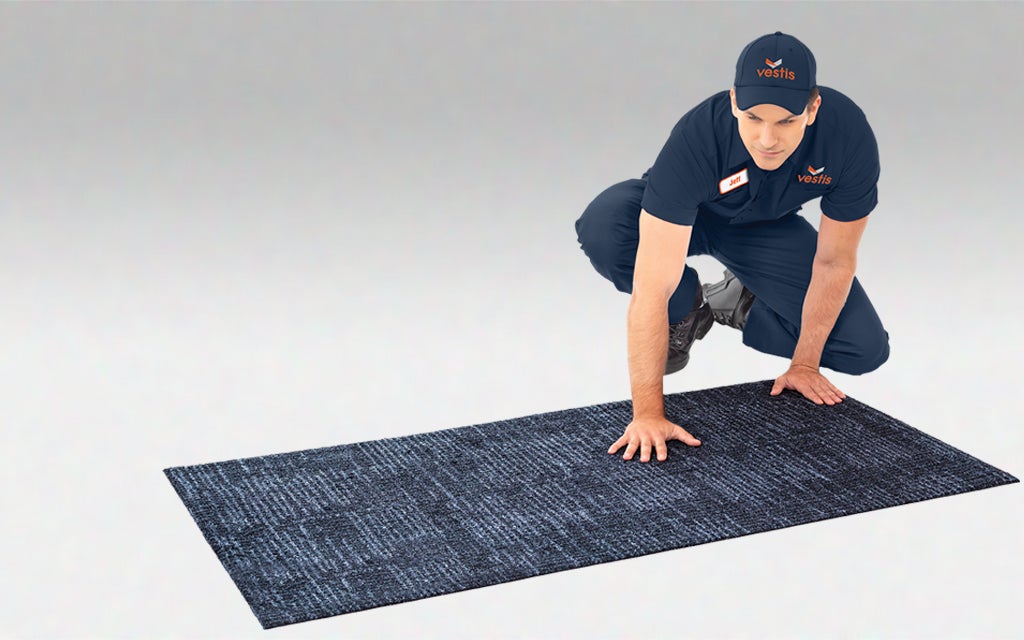 Aramark representative installing carpeted floor mat