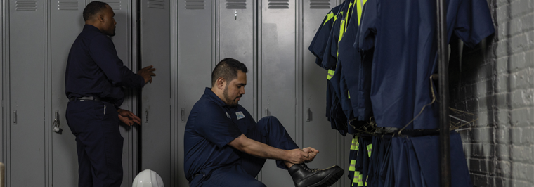 Employees getting ready for their workday in front of employee lockers