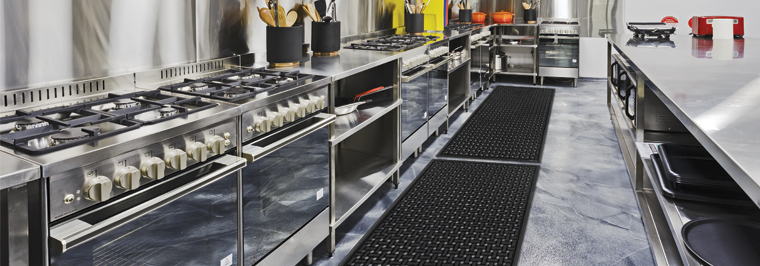 Inside restaurant kitchen with two floor mats maintained by commercial floor mat service