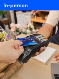 a person holding a credit card up to a terminal