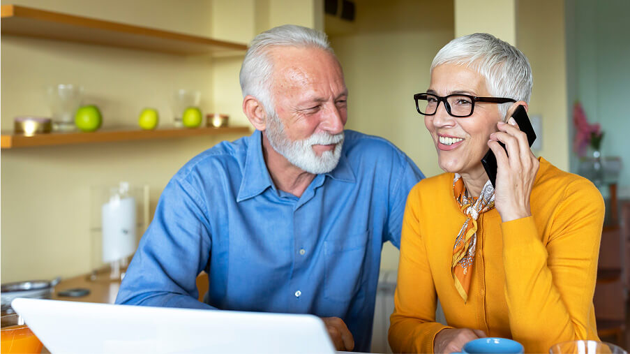 Senior couple with phone and laptop.