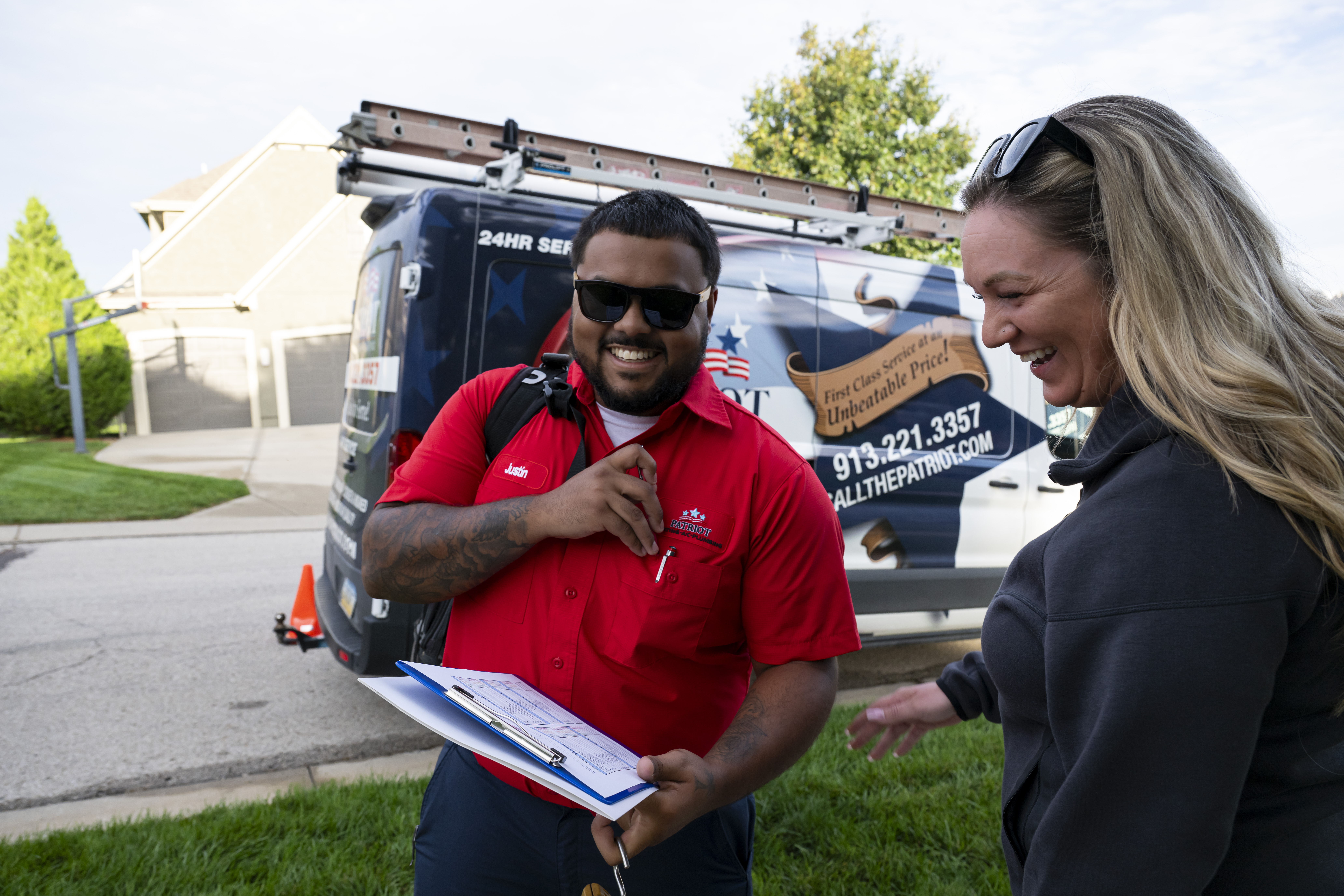 Patriot Heating & AC technician reviewing paperwork with a homeowner