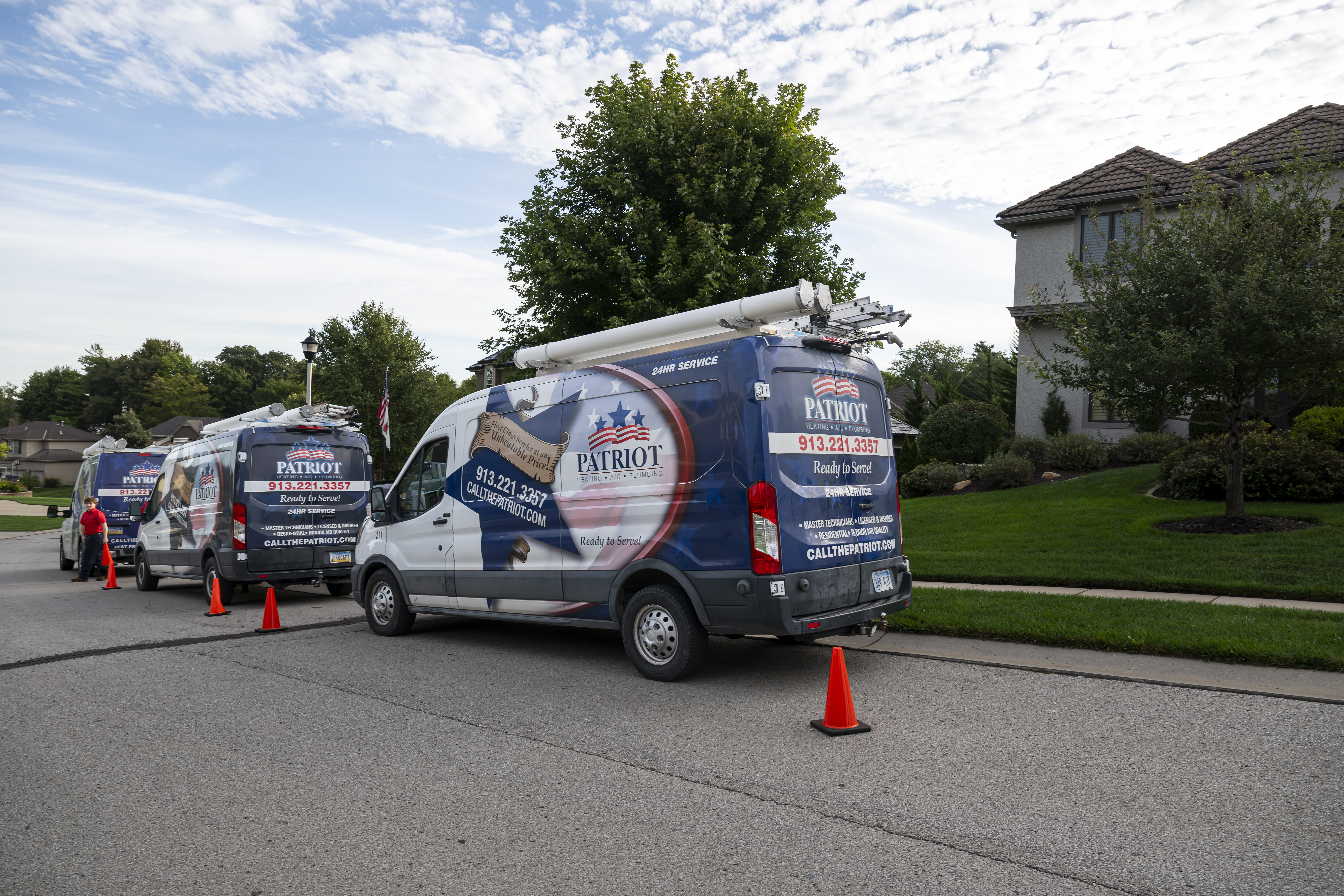 Patriot Heating & AC service vans parked on a residential street