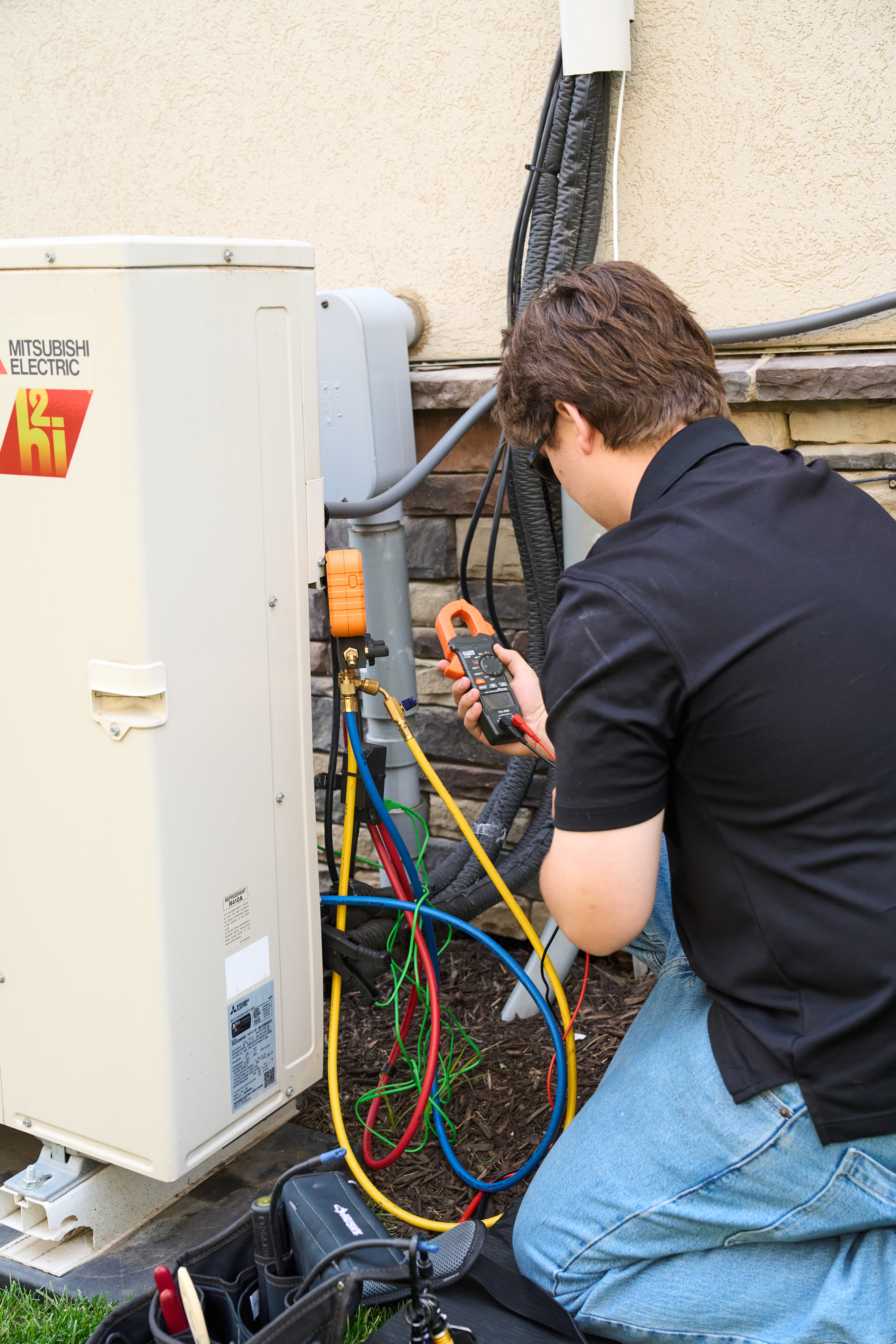 Patriot Heating & AC technician testing a Mitsubishi Electric heat pump