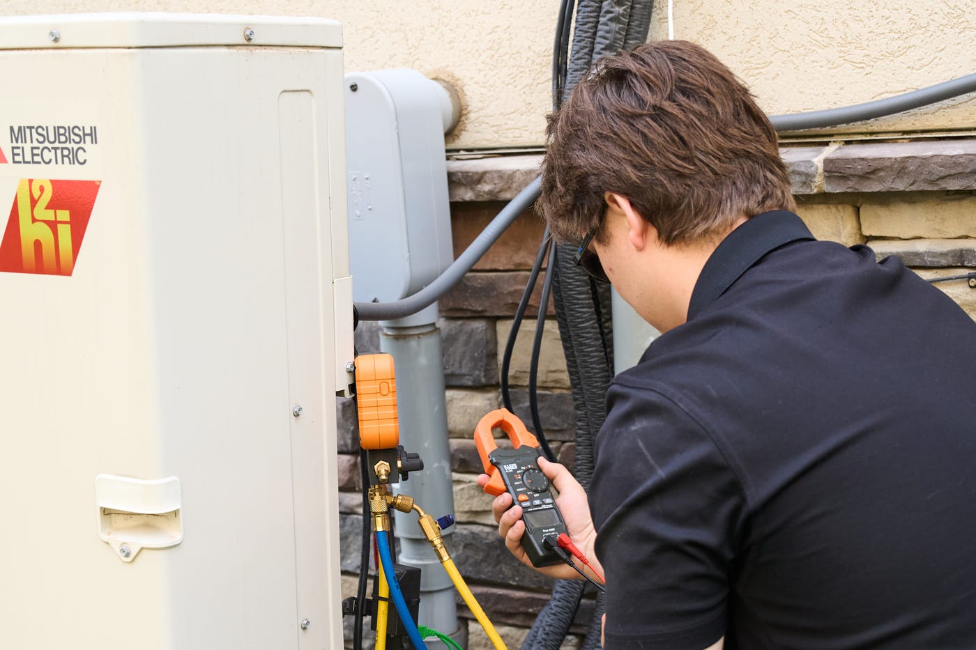 Patriot Heating & AC technician testing a Mitsubishi Electric heat pump