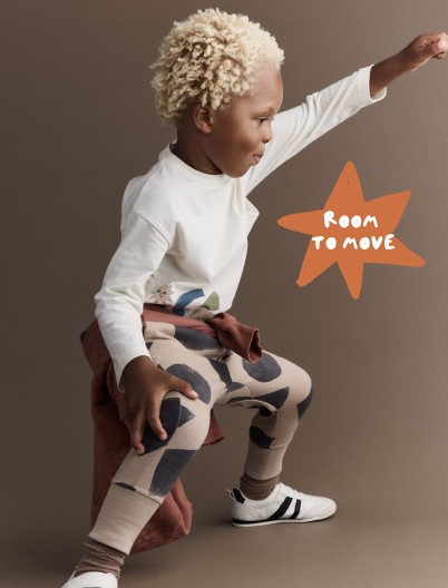 Toddler boy dressed in tee and city joggers printed with shape graphics 
