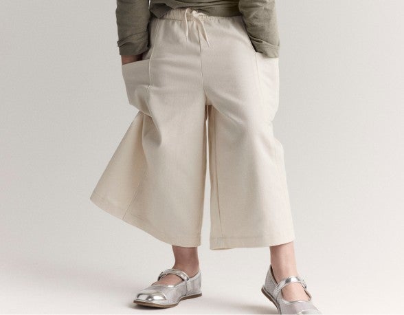 girl wearing white pants with hands in pockets