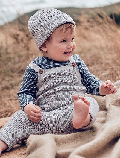 baby in knit overalls