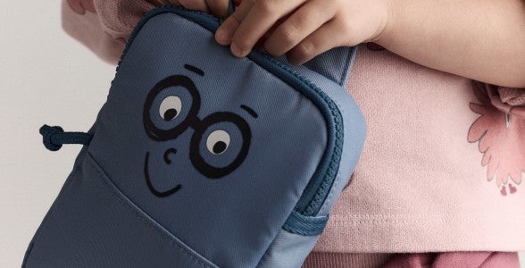 girl holding bag with face on it