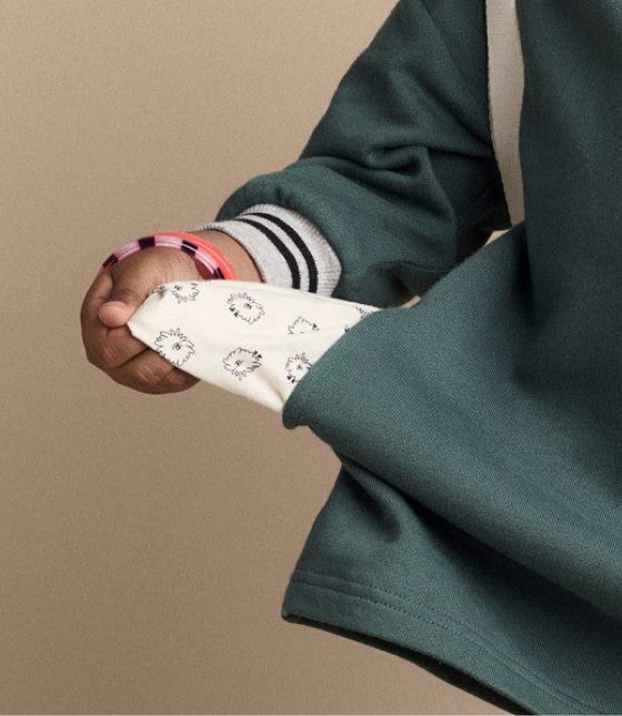 toddler pulling out pockets to reveal novelty-lined otter print