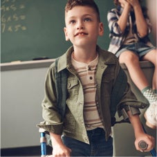 Boy with backpack and crutches in classroom