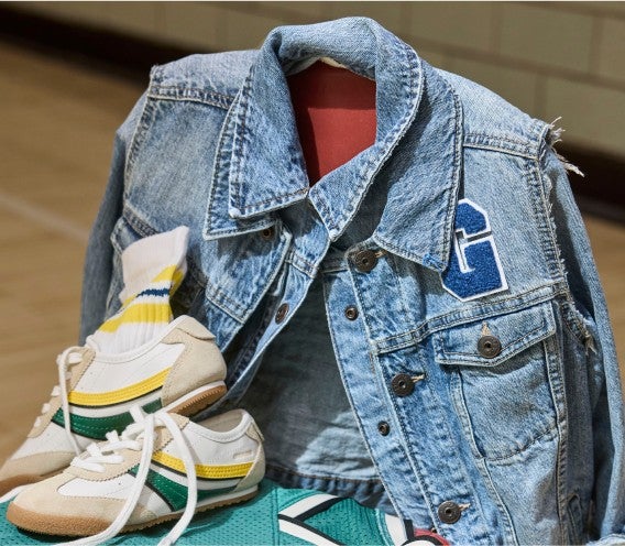 varsity denim jacket hanging on chair