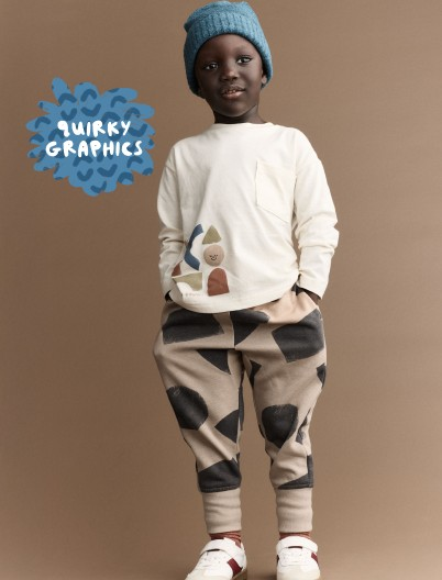Toddler boy dressed in pocket tee and city joggers printed with shape graphics
