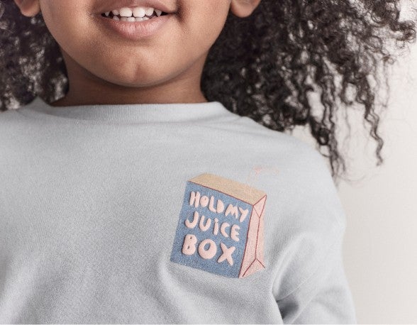 girl wearing shirt that says "hold my juice box"