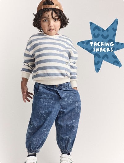 boy with striped shirt, joggers, and brown hat with hand in pocket