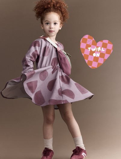 Toddler girl wearing purple dress printed with shape graphics