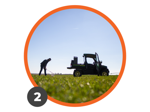 An agronomist samples soil next to a UTV with GeoPress in a field.