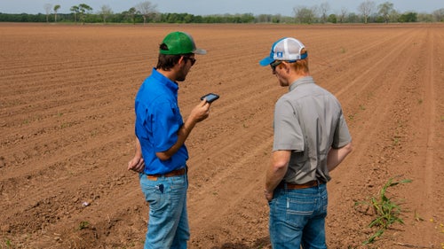 Precision Planting Premier Dealer standing in a farmers field evaluating together