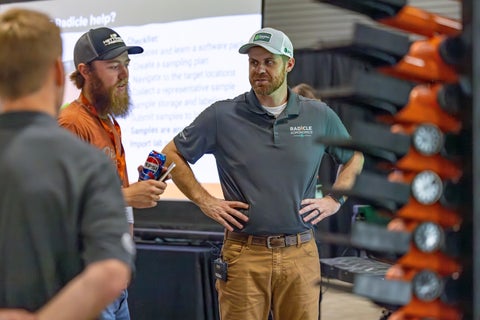 Two agronomists standing in front of a Radicle Lab