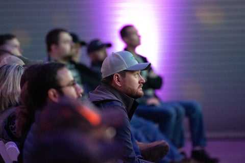 A farmer looking forward and sitting in a crowd at Precision Planting's Winter Conference.