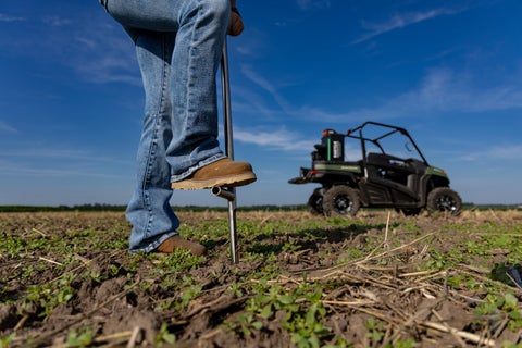 A close-up image showing a boot pressing a probe into the ground, with GeoPress Lite in the background
