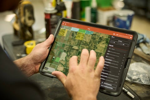 A pair of hands holding a tablet and using the Radicle App