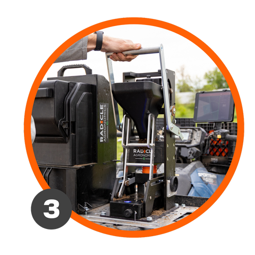 A farmer presses down on the GeoPress Lite to package soil in a GeoTube