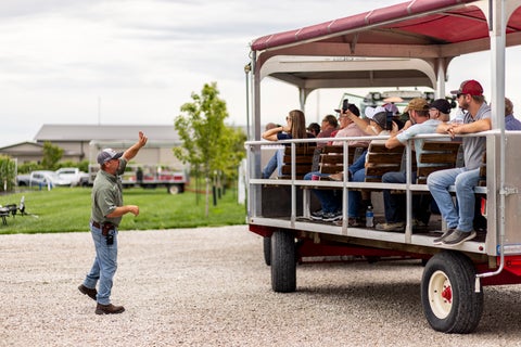 farmers on a tram at the PTI Farm listening to farm agronomist, Jason Webster