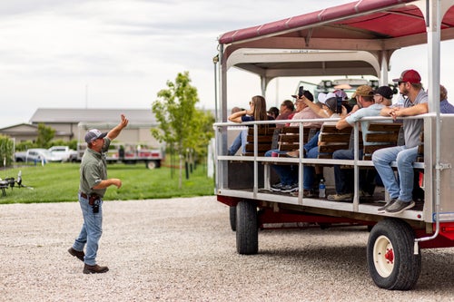 farmers on a tram at the PTI Farm listening to farm agronomist, Jason Webster