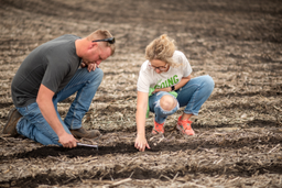 Emily and Ryan Ponwith check the furrow after planting with DeltaForce. 