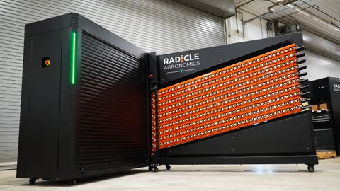 Radicle lab inside a workshop with orange GeoTubes loaded and a green status light bar.