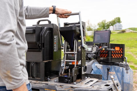 A farmer packages soil samples in GeoTubes using GeoPress Lite