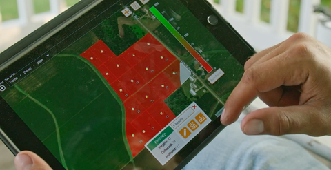 An agronomist views soil sampling data through Radicle App on a tablet device.
