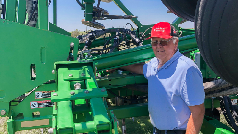 Wheat farmer Alan Wineinger stands next to his air hoe drill upgrade with Precision Planting's Clarity system