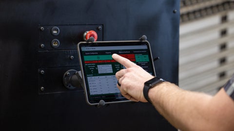 An agronomist's hand pushes the start button on a Radicle Lab tablet interface.