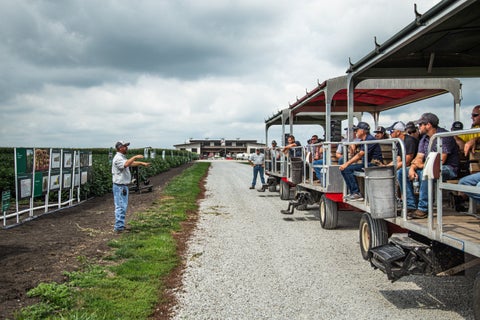 farmers on a tram at the PTI Farm listening to farm agronomist, Jason Webster