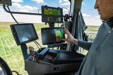 Farmer in tractor cab using 20|20 while planting