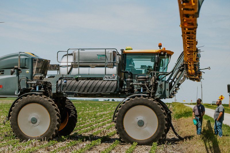 Applicator technicians stand by a sprayer as Precision Planting's ReClaim primes the booms