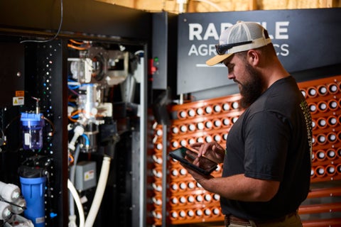 An agronomist presses the start button on Radicle Lab's control screen.