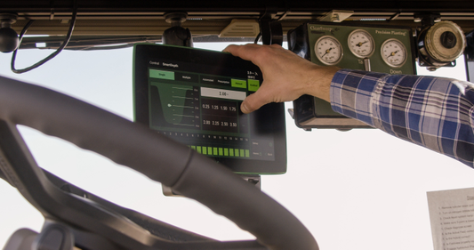 Farmer touches a Precision Planting 20|20 Gen 3 display in a tractor cab